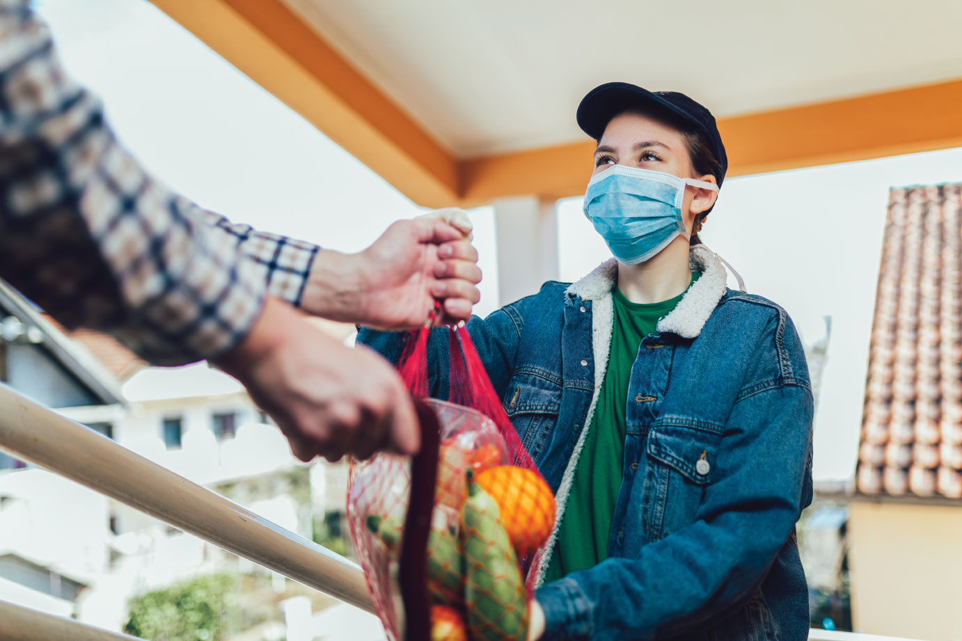 Teenage girl is delivering some groceries and wearing a face mask.