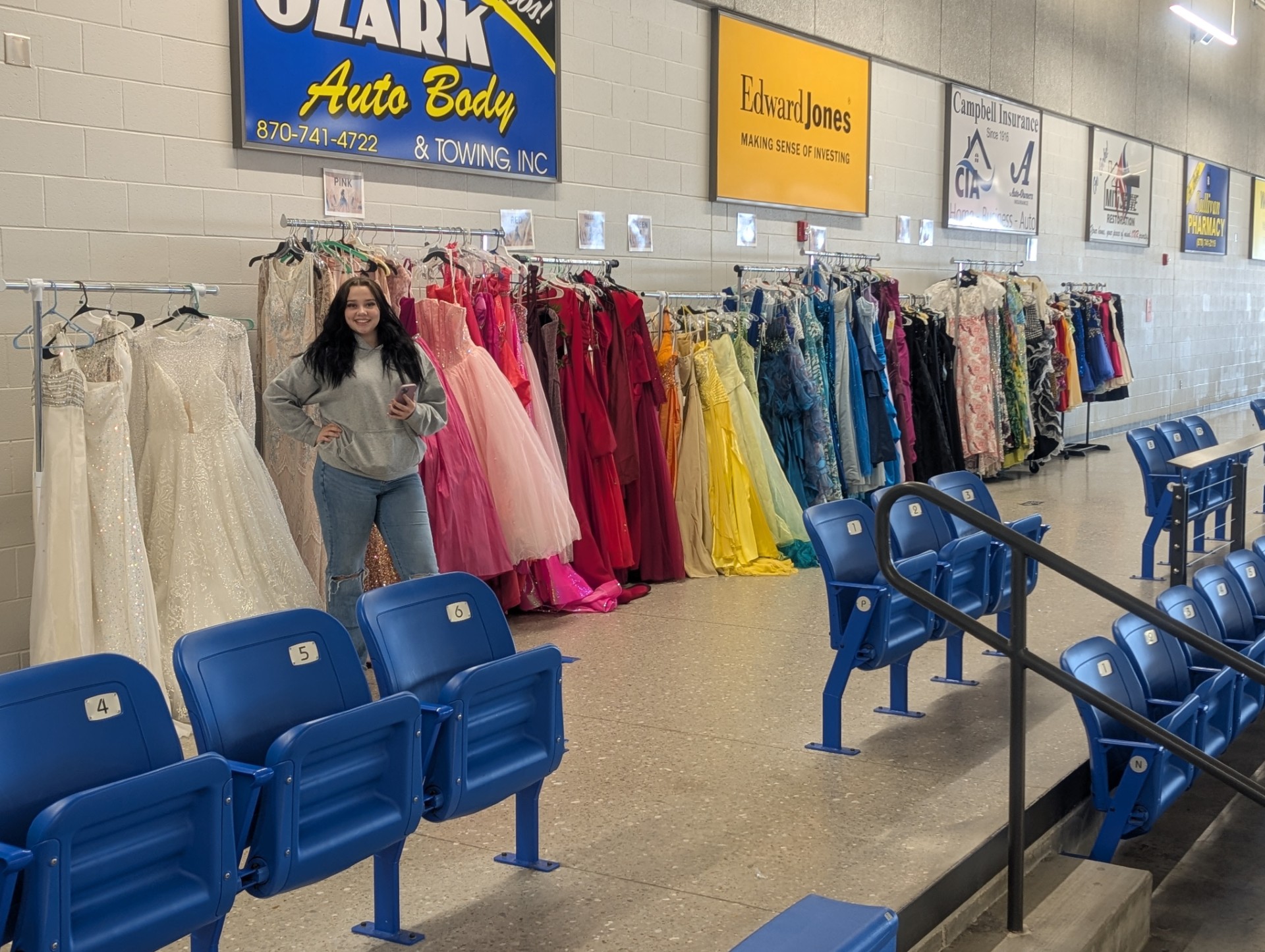 A Key Club student at Harrison High School in Harrison, AR, with donated dresses for “The Promise Project.” Photo courtesy of Jay Parker.